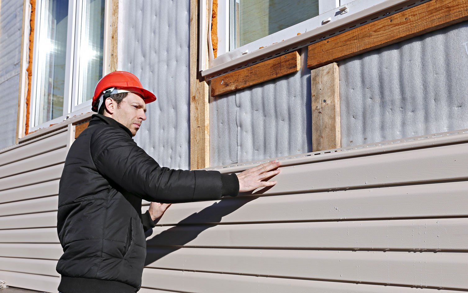 A Worker installs siding